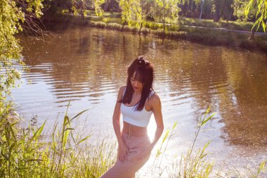 Güneşin doğuşunda gölün yanında güzel genç bir kadın