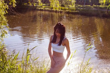 Güneşin doğuşunda gölün yanında güzel genç bir kadın