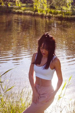 Güneşin doğuşunda gölün yanında güzel genç bir kadın