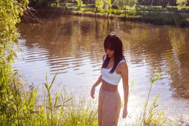 Güneşin doğuşunda gölün yanında güzel genç bir kadın