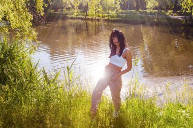 Güneşin doğuşunda gölün yanında güzel genç bir kadın