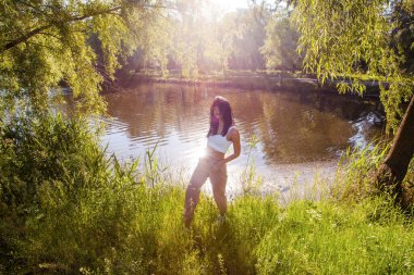 Güneşin doğuşunda gölün yanında güzel genç bir kadın
