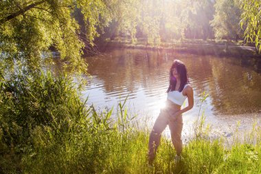 Güneşin doğuşunda gölün yanında güzel genç bir kadın