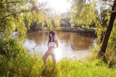 Güneşin doğuşunda gölün yanında güzel genç bir kadın