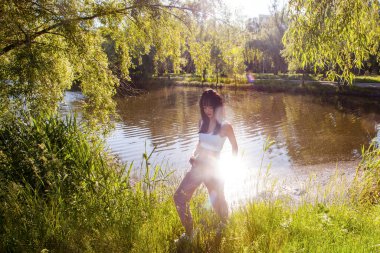 Güneşin doğuşunda gölün yanında güzel genç bir kadın