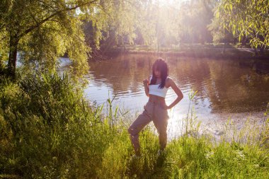 Güneşin doğuşunda gölün yanında güzel genç bir kadın