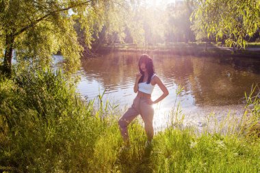 Güneşin doğuşunda gölün yanında güzel genç bir kadın