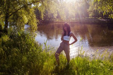 Güneşin doğuşunda gölün yanında güzel genç bir kadın