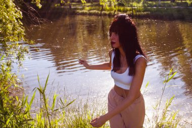 Güneşin doğuşunda gölün yanında güzel genç bir kadın