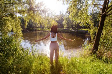Güneşin doğuşunda gölün yanında güzel genç bir kadın