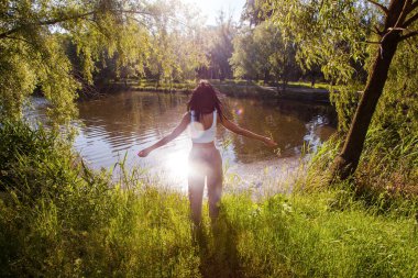Güneşin doğuşunda gölün yanında güzel genç bir kadın