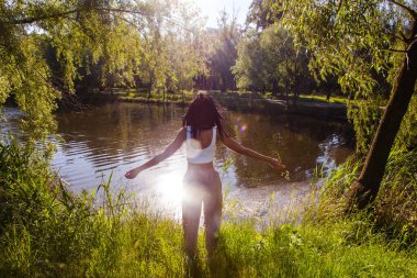 Güneşin doğuşunda gölün yanında güzel genç bir kadın