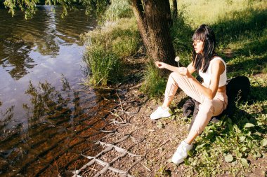 Güneşin doğuşunda gölün yanında güzel genç bir kadın