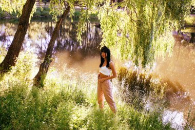 Güneşin doğuşunda gölün yanında güzel genç bir kadın