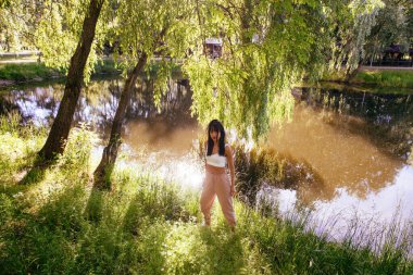 Güneşin doğuşunda gölün yanında güzel genç bir kadın