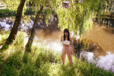 Güneşin doğuşunda gölün yanında güzel genç bir kadın