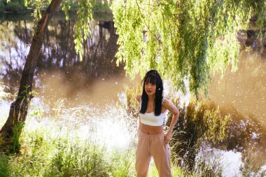 Güneşin doğuşunda gölün yanında güzel genç bir kadın