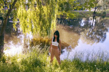 Güneşin doğuşunda gölün yanında güzel genç bir kadın