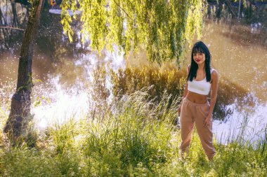 Güneşin doğuşunda gölün yanında güzel genç bir kadın