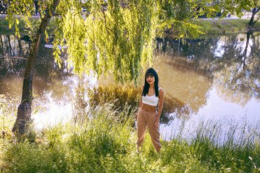 Güneşin doğuşunda gölün yanında güzel genç bir kadın