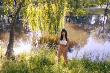 Güneşin doğuşunda gölün yanında güzel genç bir kadın