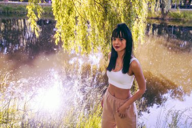 Güneşin doğuşunda gölün yanında güzel genç bir kadın