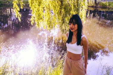 Güneşin doğuşunda gölün yanında güzel genç bir kadın