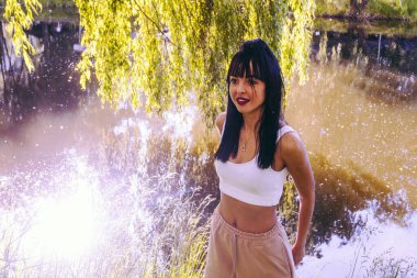 Güneşin doğuşunda gölün yanında güzel genç bir kadın