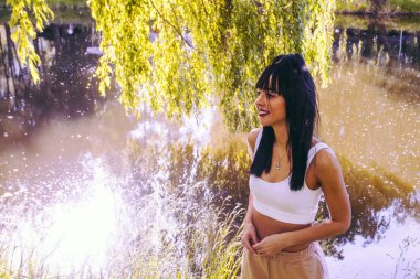 Güneşin doğuşunda gölün yanında güzel genç bir kadın