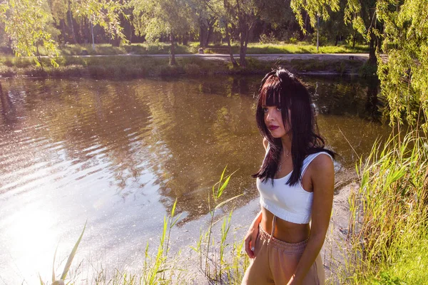 Güneşin doğuşunda gölün yanında güzel genç bir kadın