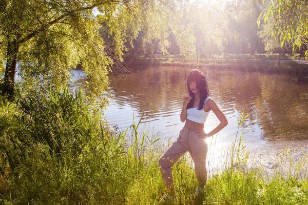 Güneşin doğuşunda gölün yanında güzel genç bir kadın