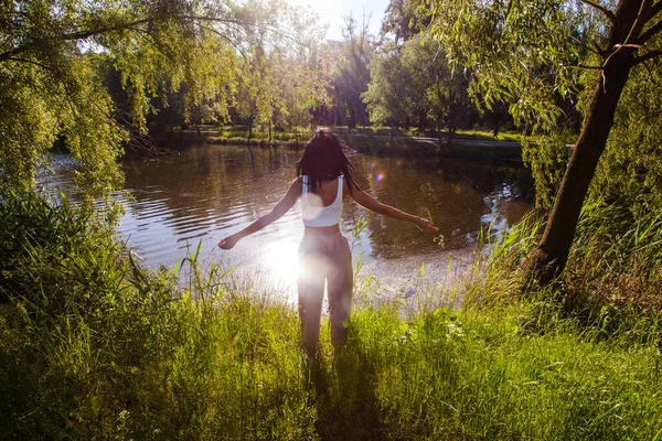 Güneşin doğuşunda gölün yanında güzel genç bir kadın