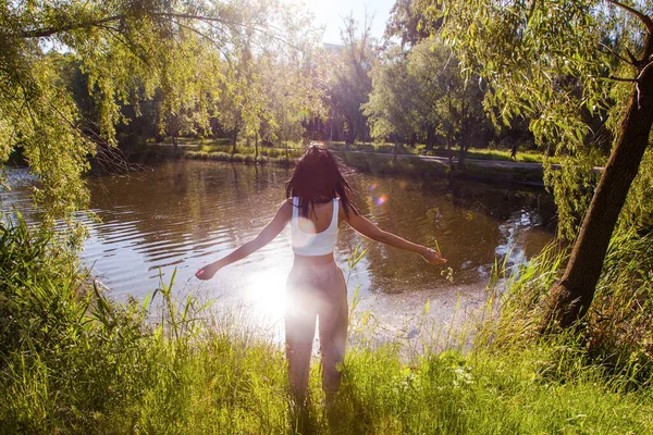 Güneşin doğuşunda gölün yanında güzel genç bir kadın