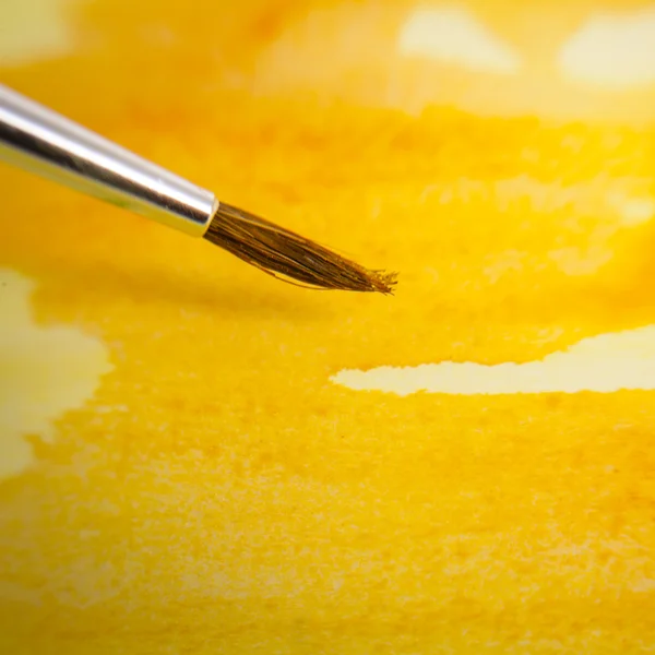 Yellow painted background and brush — Stock Photo, Image