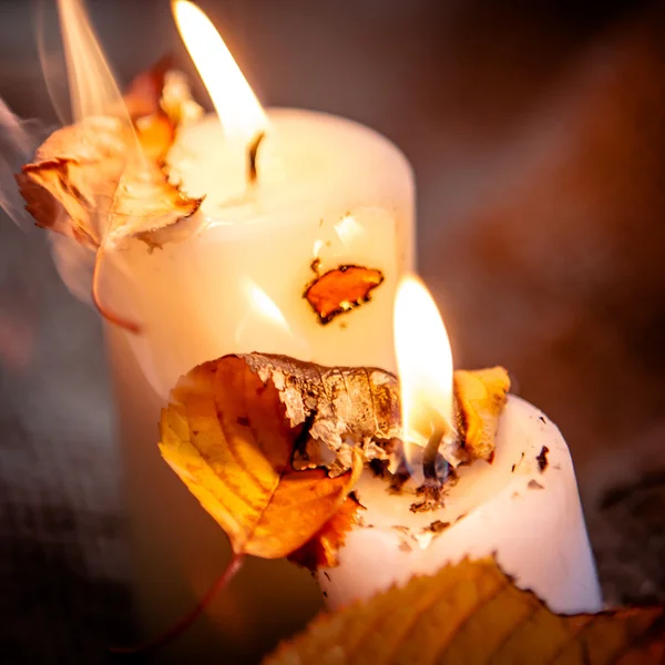 Foglie d'acero secche e luce calda delle candele — Foto Stock