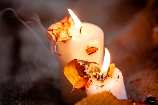 Foglie d'acero secche e luce calda delle candele — Foto Stock