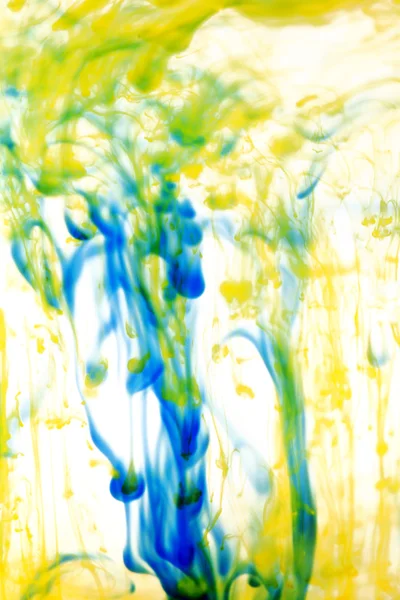 Líquido azul e amarelo na água — Fotografia de Stock