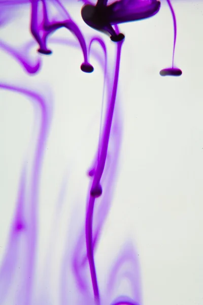 Фиолетовая жидкость в воде — стоковое фото