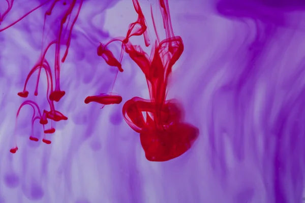 Líquido vermelho e violeta na água — Fotografia de Stock