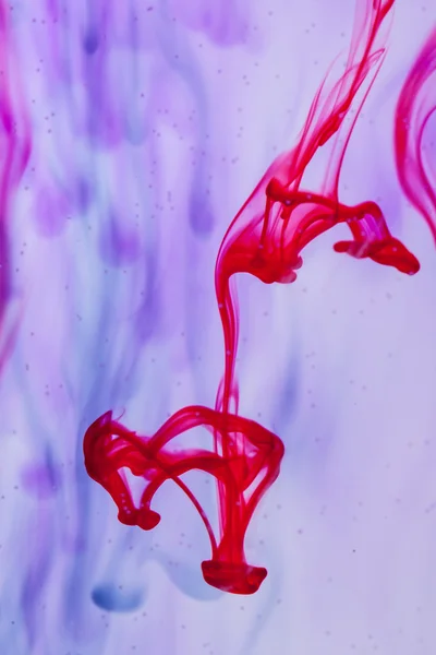 Líquido rojo y violeta en agua — Foto de Stock