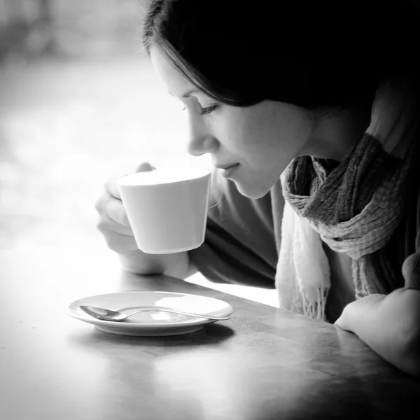 Красивая молодая женщина с чашкой чая в кафе — стоковое фото