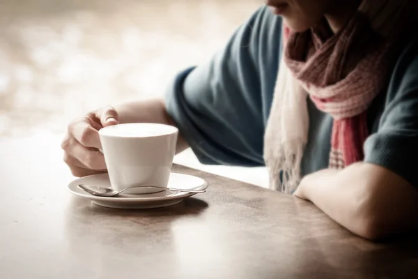 Γυναίκα χέρια με latte σε ένα ξύλινο τραπέζι — Φωτογραφία Αρχείου