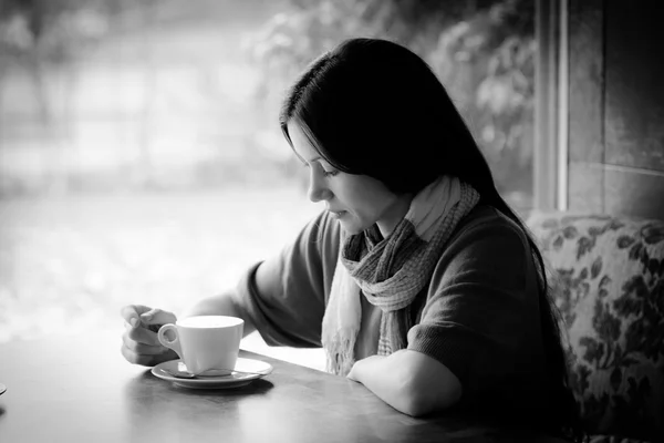 Schöne junge Frau mit einer Tasse Tee in einem Café — Stockfoto