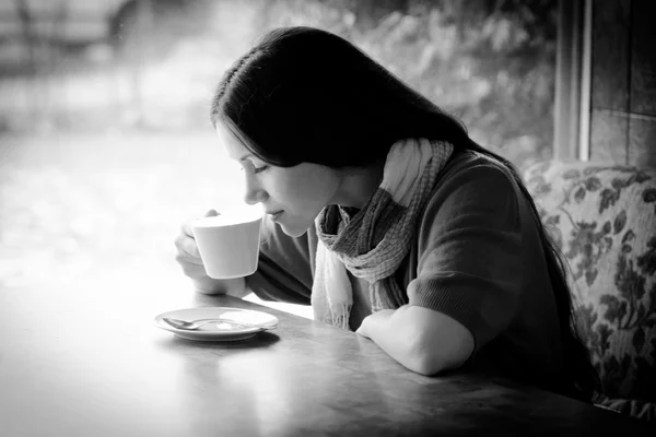 Schöne junge Frau mit einer Tasse Tee in einem Café — Stockfoto