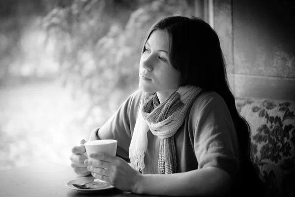 Bella giovane donna con una tazza di tè in un caffè — Foto Stock