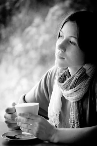 Beautiful young woman with a cup of tea at a cafe — Stock Photo, Image