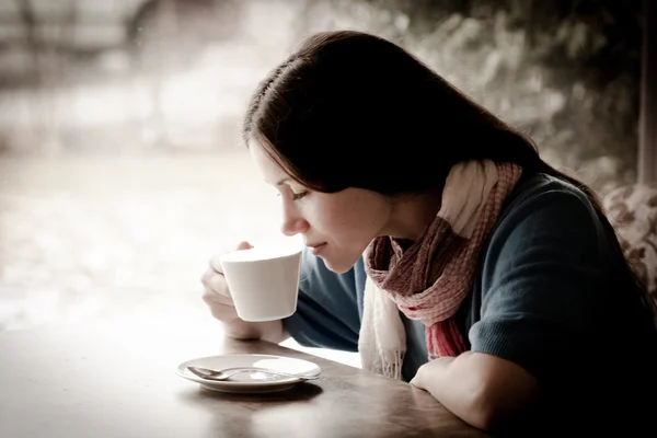 Beautiful young woman with a cup of tea at a cafe — Stock Photo, Image