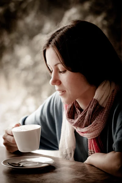 Beautiful young woman with a cup of tea at a cafe — Stock Photo, Image