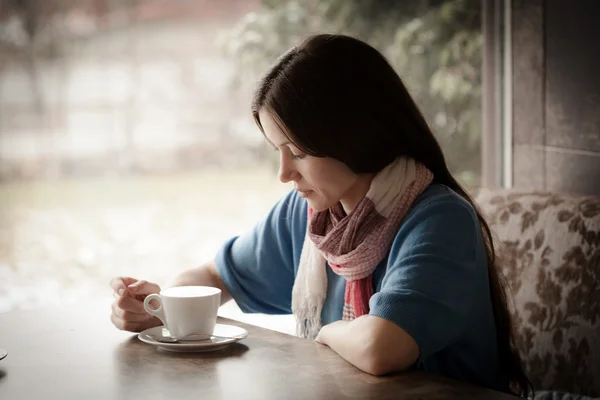 Beautiful young woman with a cup of tea at a cafe — Stock Photo, Image