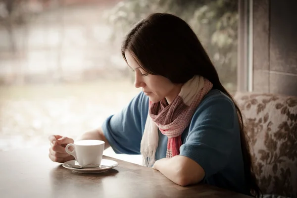 Beautiful young woman with a cup of tea at a cafe — Stock Photo, Image